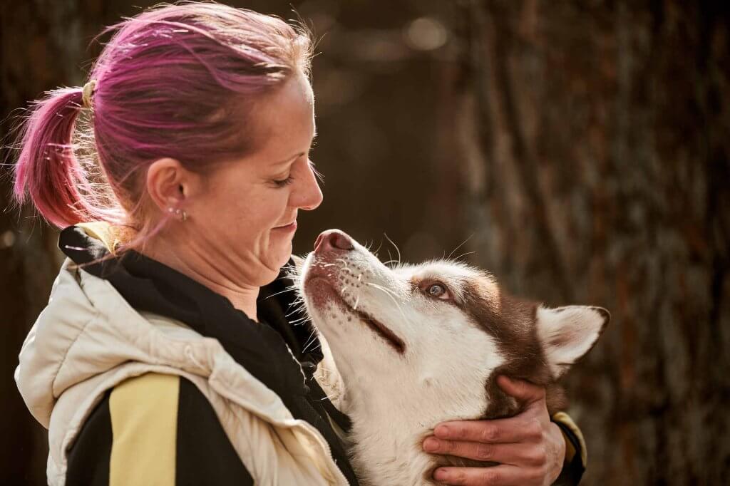 A woman hugging a Husky dog
